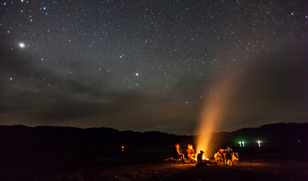 night sky with people around a campfire